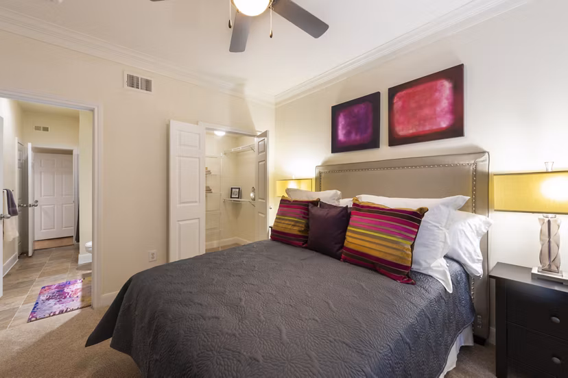 Cozy bedroom with modern furnishings at The Village at West University Apartments