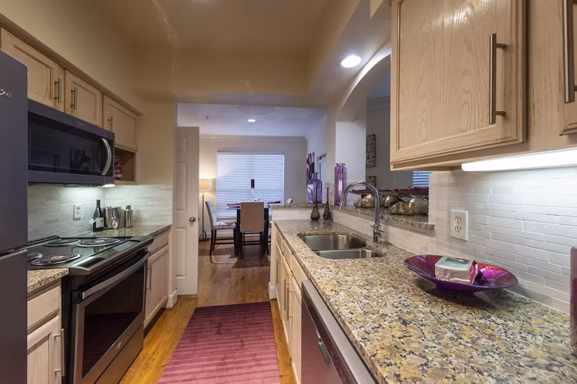 Modern kitchen with sleek stainless steel appliances at The Village at West University Apartments