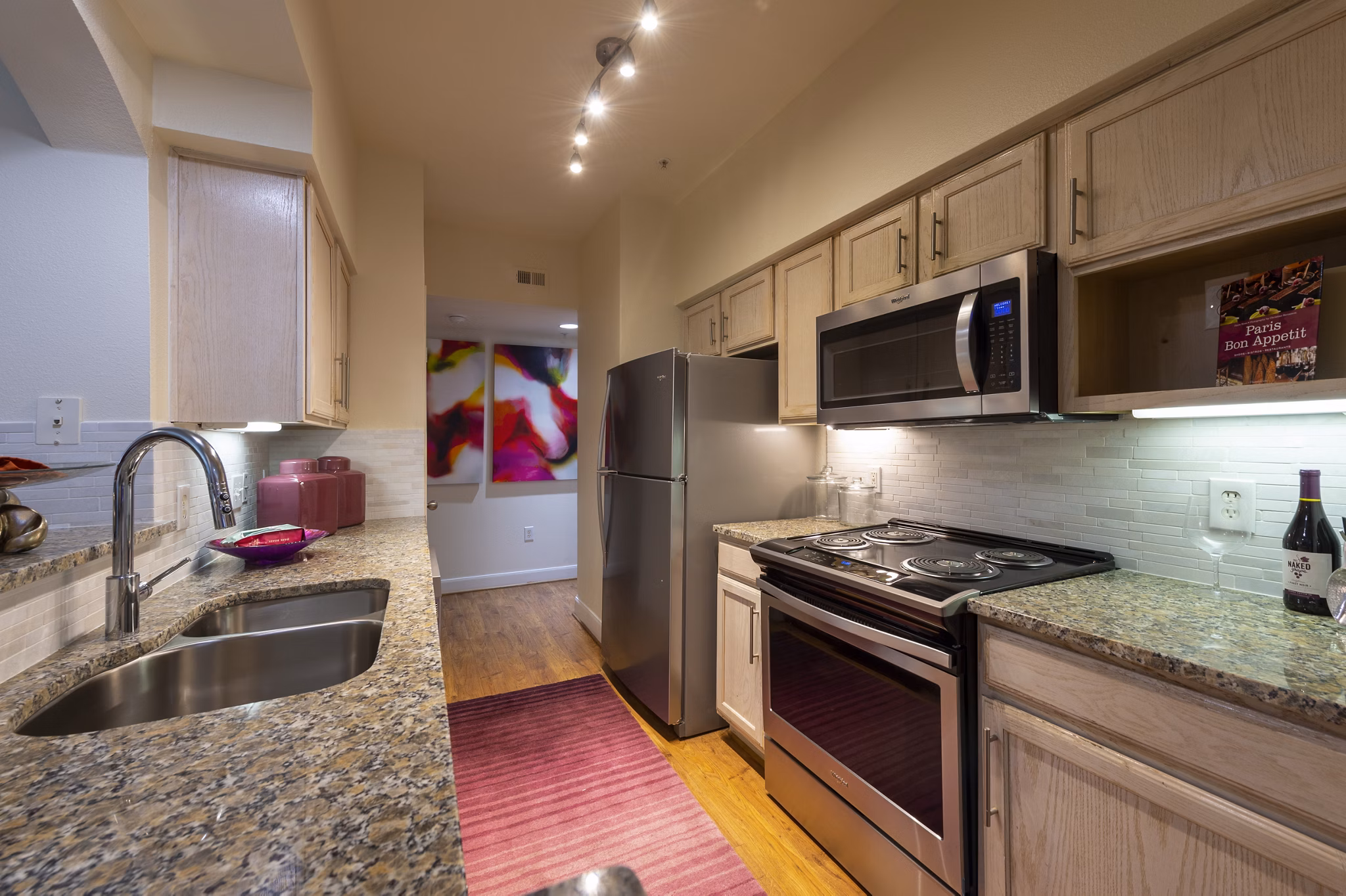 Modern kitchen with stainless steel appliances at The Village at West University Apartments