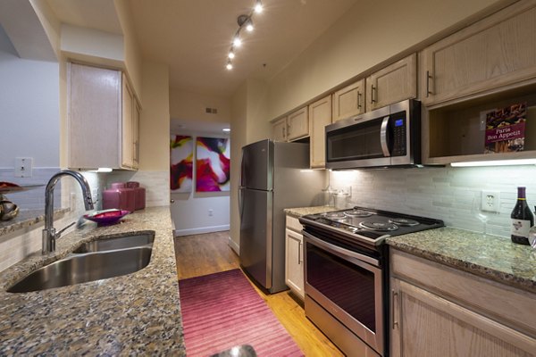 Modern kitchen with stainless steel appliances at The Village at West University Apartments
