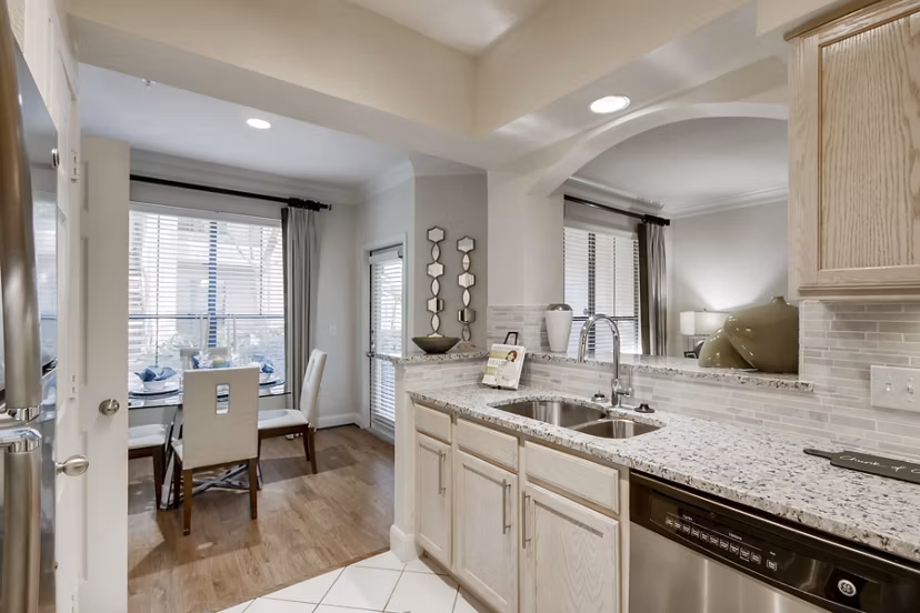 Modern kitchen with stainless steel appliances at The Village at West University Apartments