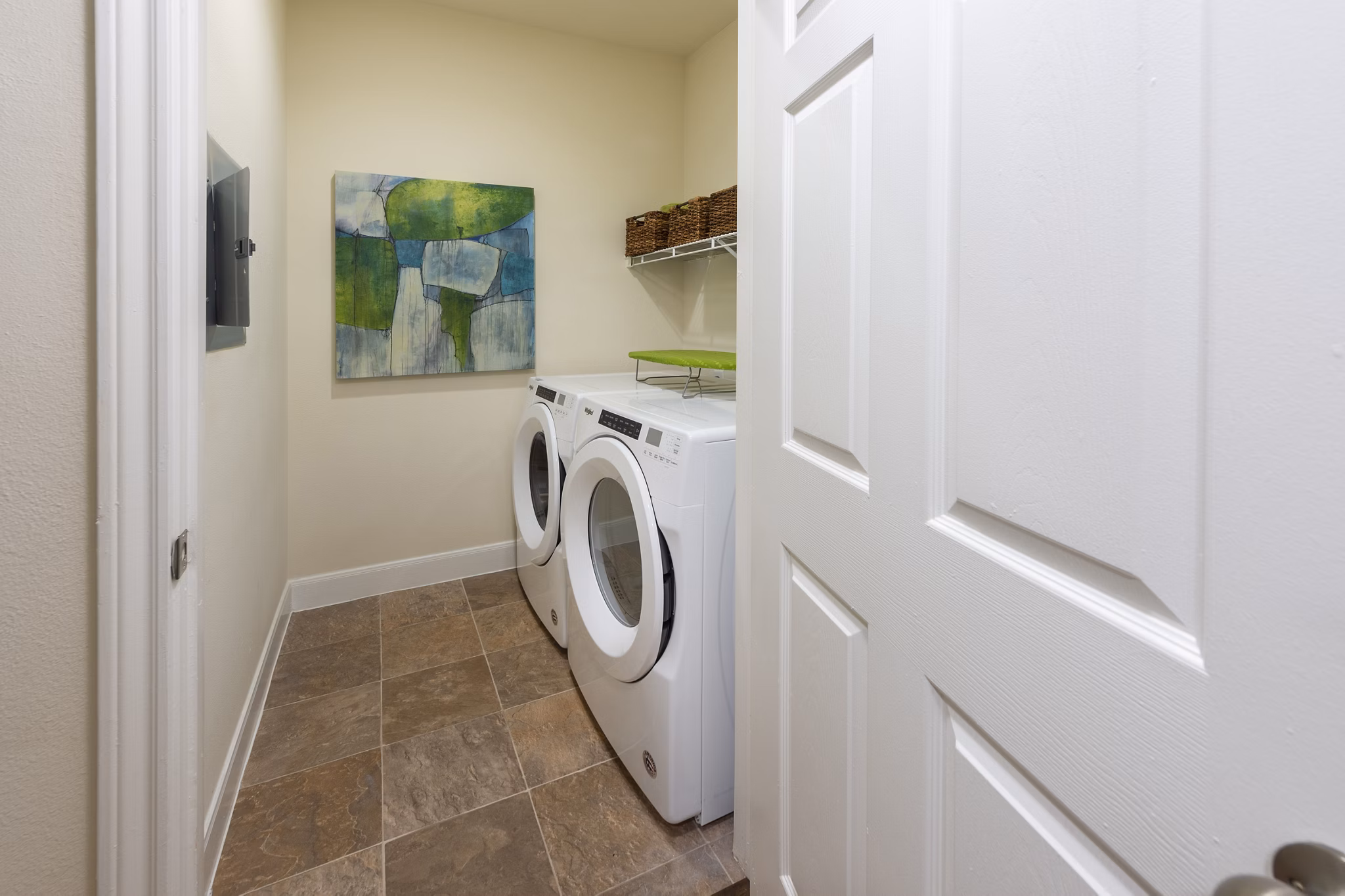 Laundry room with modern appliances and ample storage at The Village at West University Apartments