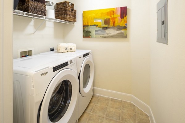 Laundry room with modern appliances at The Village at West University Apartments