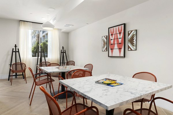 â€œElegant meeting room with tables, chairs, and artwork in luxury apartmentsâ€