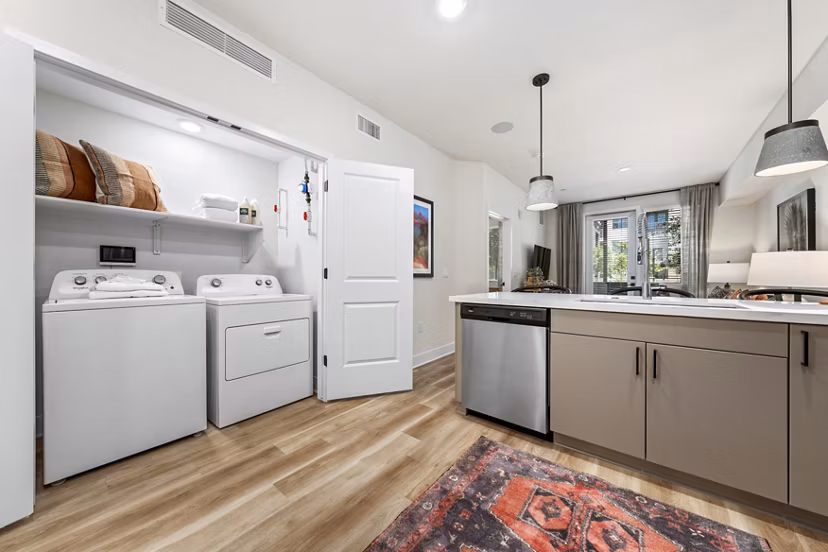 Modern kitchen with stainless steel appliances and in-unit laundry at Overture Arcadia Apartments