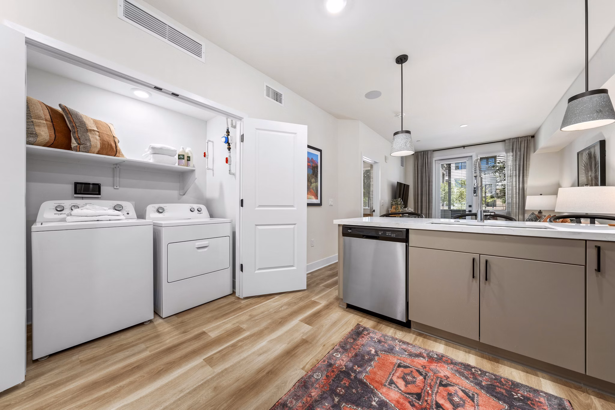 Modern kitchen with stainless steel appliances and in-unit laundry at Overture Arcadia Apartments