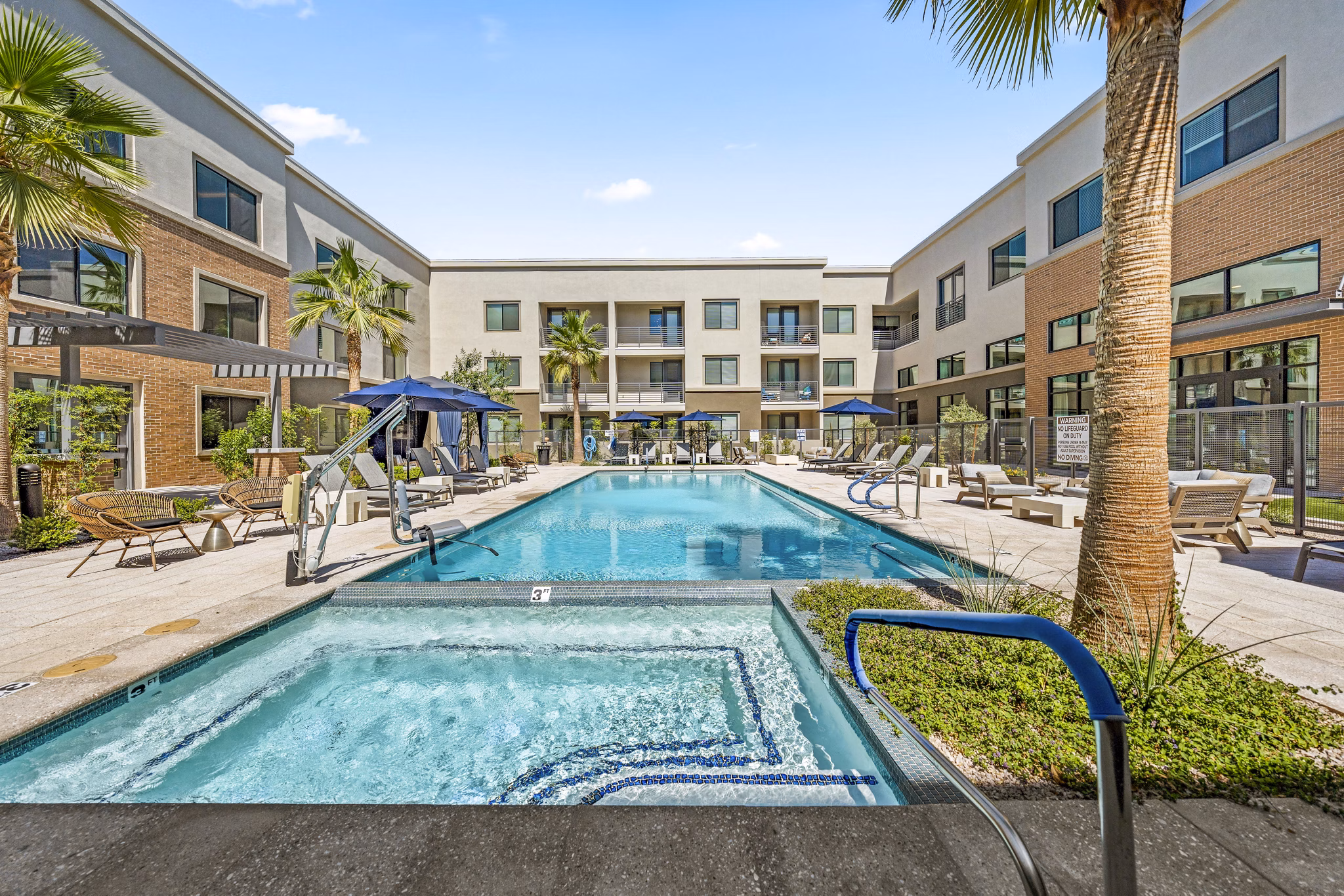 Overture Arcadia Apartments: Serene pool area with lounge seating and greenery, ideal for relaxation and socializing in Scottsdale.
