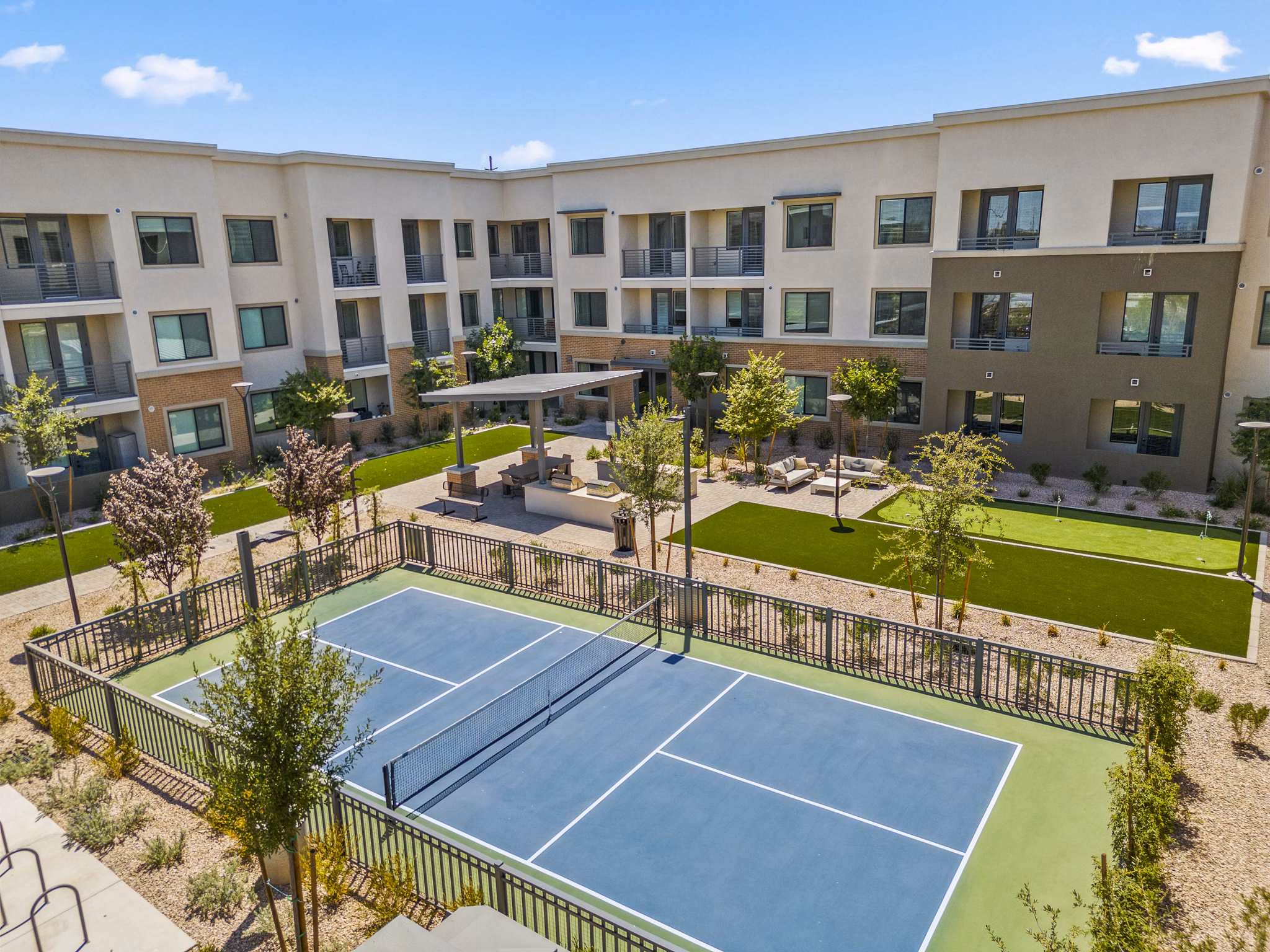 Outdoor tennis court with lush surroundings at Overture Arcadia Apartments, perfect for recreation and fitness enthusiasts