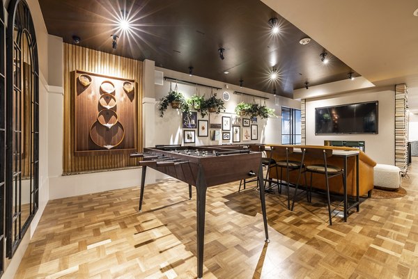 Game room with modern pool table and gaming consoles at Ballard Yards Apartments Luxurious social space for residents to enjoy leisure activities