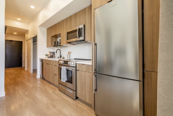 Modern kitchen featuring stainless steel appliances and granite countertops in Ballard Yards Apartments