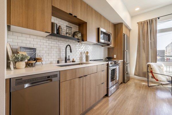 Modern kitchen featuring stainless steel appliances and granite countertops in Ballard Yards Apartments