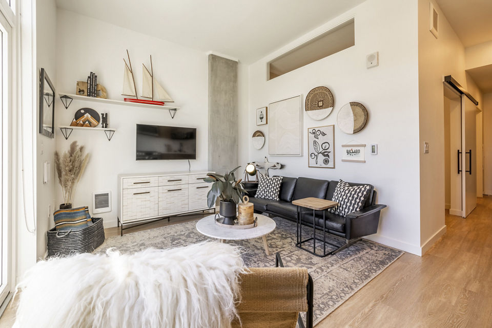 Modern living room with sleek furniture at Ballard Yards Apartments, featuring plush seating and ample natural light in Seattle