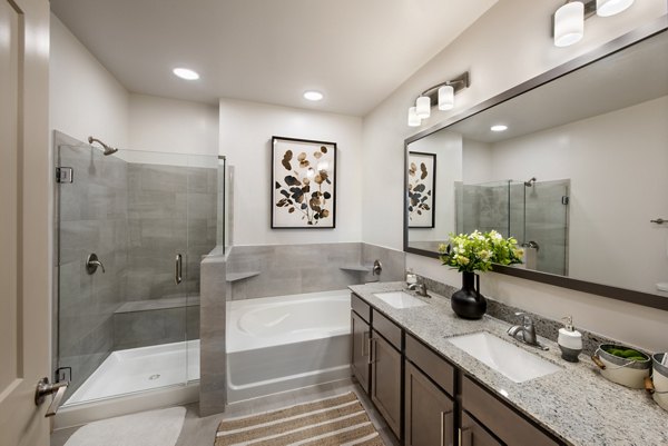 Modern bathroom with marble countertops and sleek fixtures in Henry House at Clift Farm Apartments