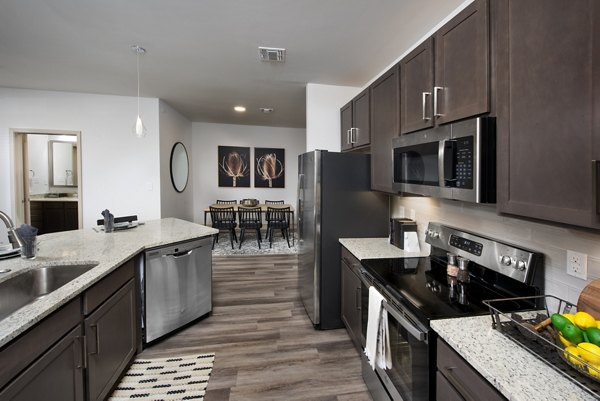 Kitchen with modern appliances and sleek countertops in Henry House at Clift Farm Apartments