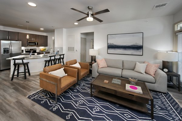 Stylish living room with modern decor at Henry House at Clift Farm Apartments, featuring plush seating and large windows