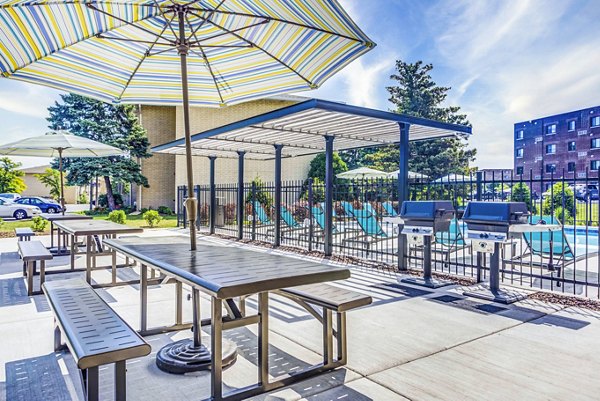 Outdoor grill area with modern patio seating at Orion Elk Grove Apartments, ideal for socializing in a serene environment