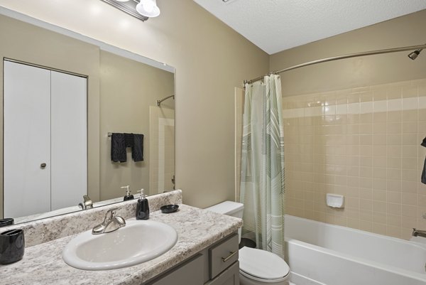 Modern bathroom featuring sleek fixtures and ample lighting in Concord Apartments