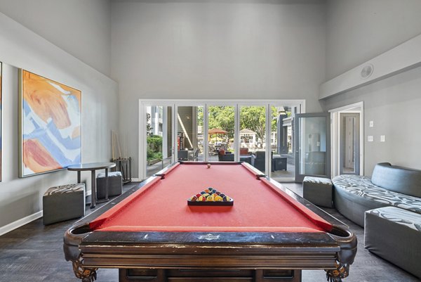 Game room with a red pool table and cozy seating areas for relaxation