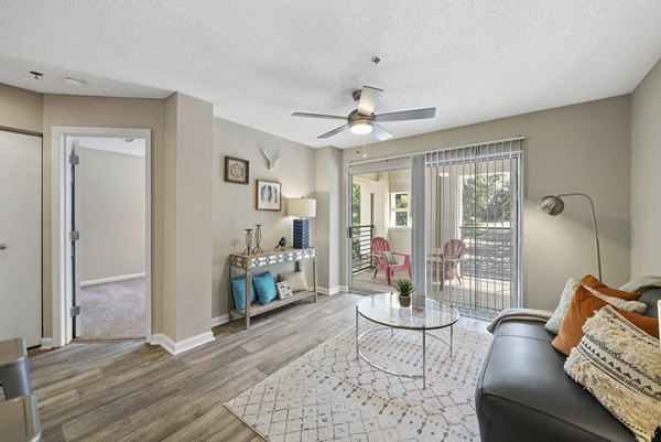 Spacious living room with modern furnishings and large windows in Concord Apartments