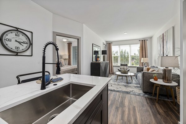 Modern kitchen with stainless steel appliances and island at The Easley Apartments