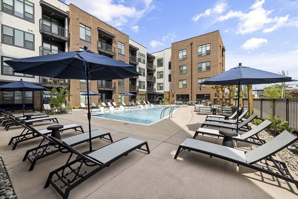 Inviting outdoor pool area at The Easley Apartments with lounge seating and landscaped surroundings, providing a luxury retreat for residents