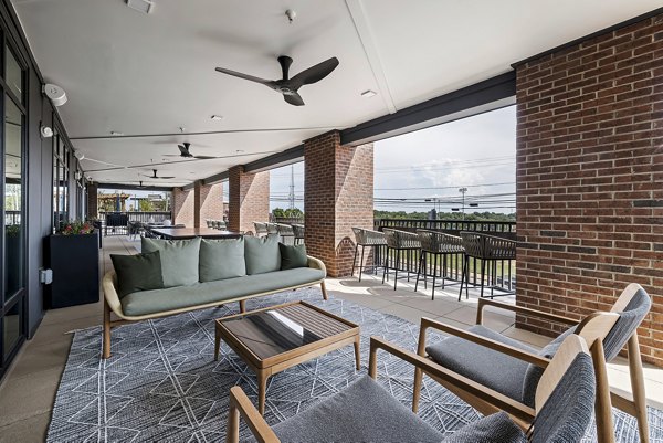 Chic patio with cozy seating and string lights at The Easley Apartments, perfect for outdoor relaxation and socializing