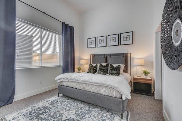 Cozy bedroom with modern decor and ample natural light in The Heights at Legend Hills Apartments
