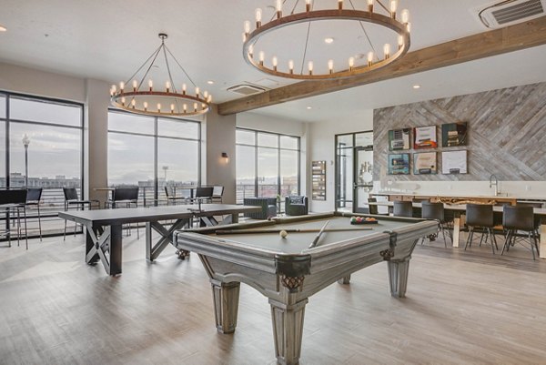 Game room with arcade machines and billiards at The Heights at Legend Hills Apartments Fun community space for residents to unwind and socialize