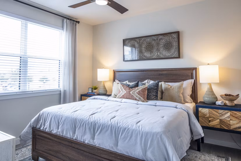 Stylish bedroom featuring large windows and modern decor at Prose Hardy Yards Apartments