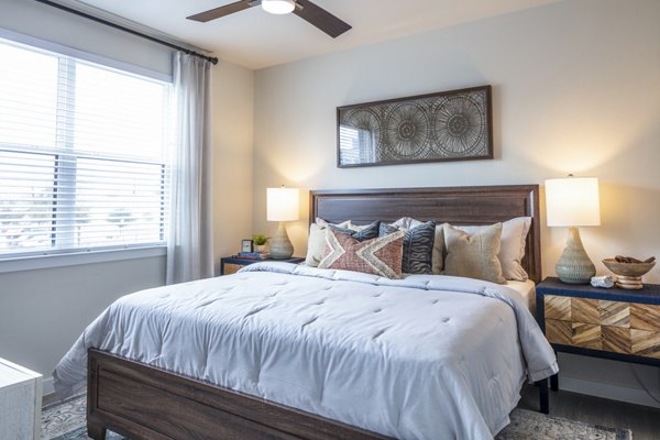 Stylish bedroom featuring large windows and modern decor at Prose Hardy Yards Apartments