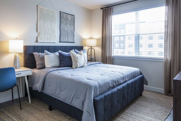 Bedroom with modern decor and large windows at Prose Hardy Yards Apartments in Houston