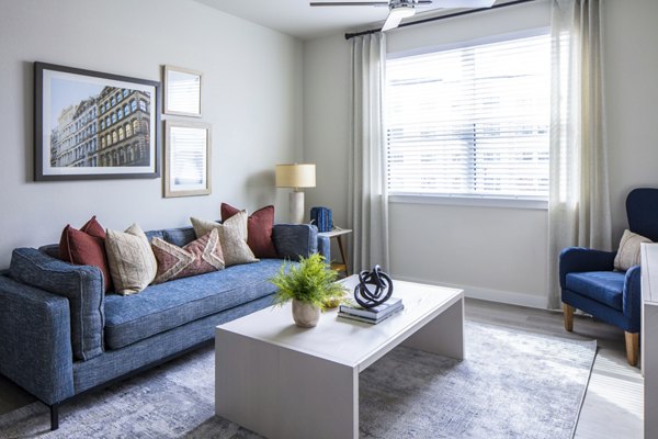 Modern living room with sleek furniture and large windows in Prose Hardy Yards Apartments, offering luxury living in Houston