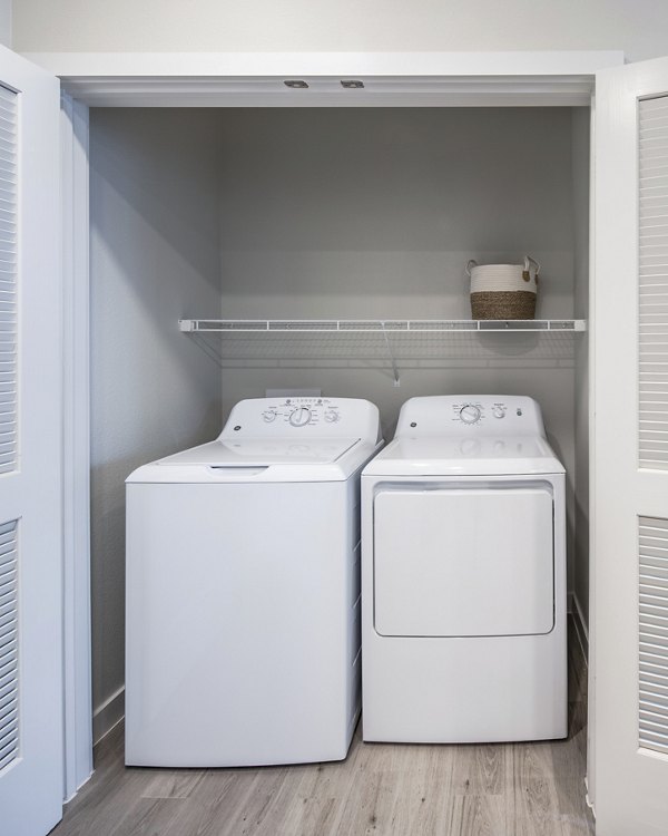 Laundry room with modern appliances at Prose Hardy Yards Apartments