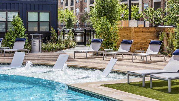 Inviting swimming pool with lounge chairs at Prose Hardy Yards Apartments