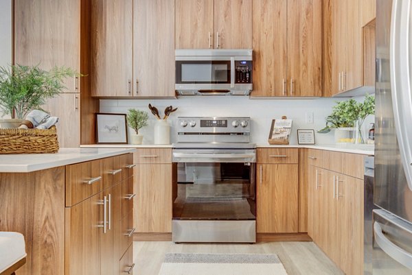 Elegant kitchen with stainless steel appliances and granite countertops in Aspire Apartments