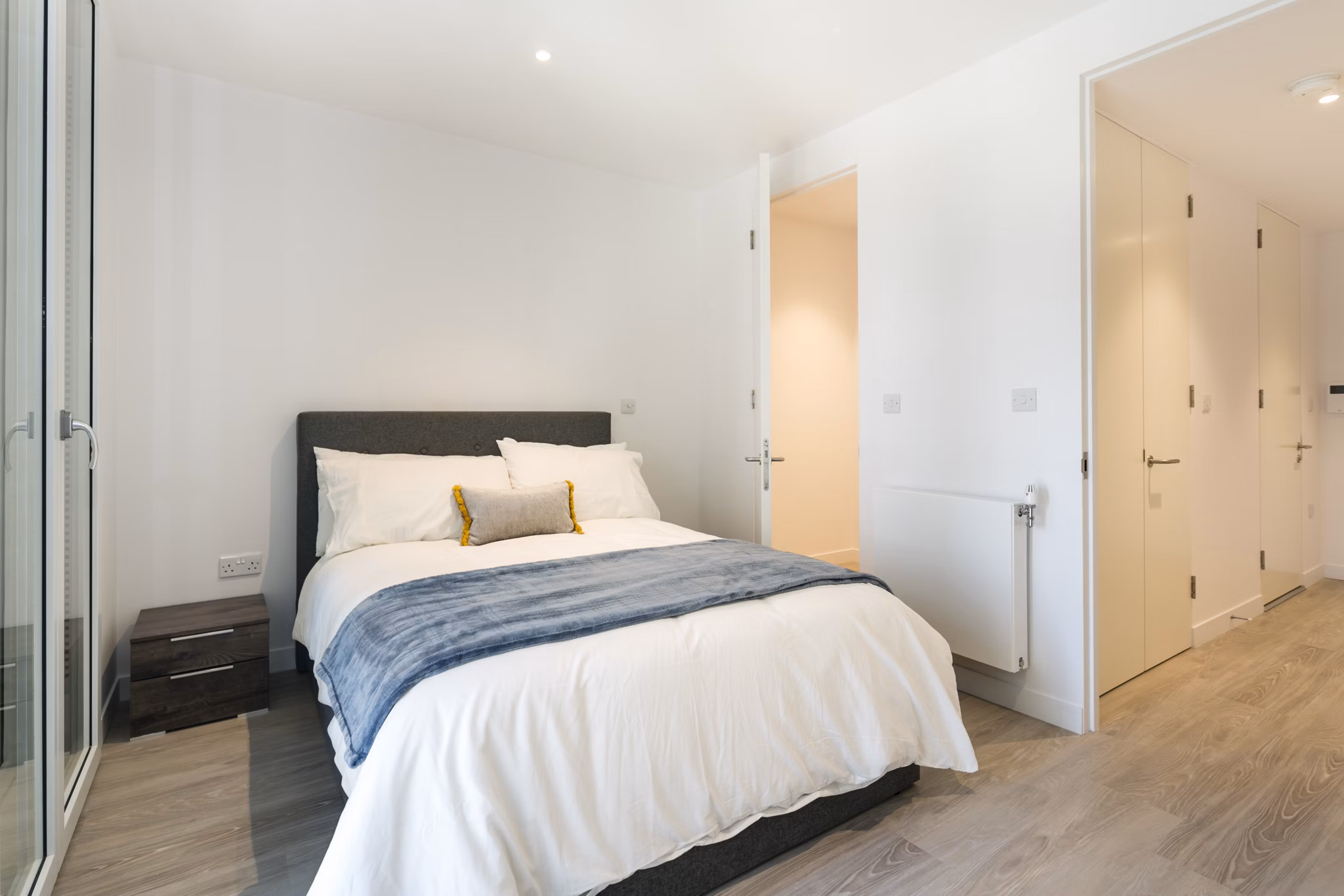 Elegant bedroom with a comfortable bed, soft linens, and minimalistic decor creating a calming atmosphere.