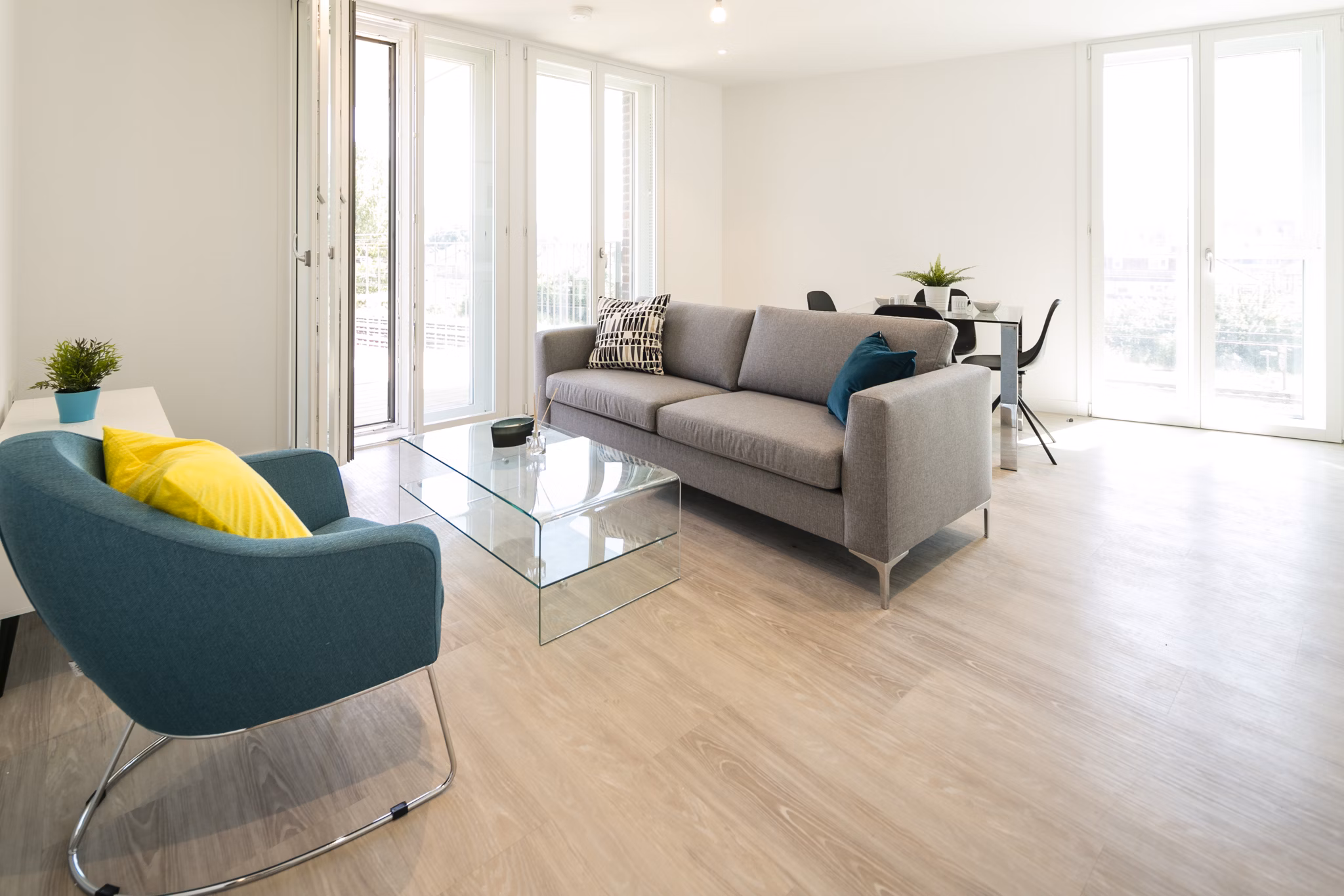 Bright and airy living room with modern furniture, floor-to-ceiling windows, and natural light illuminating the space.