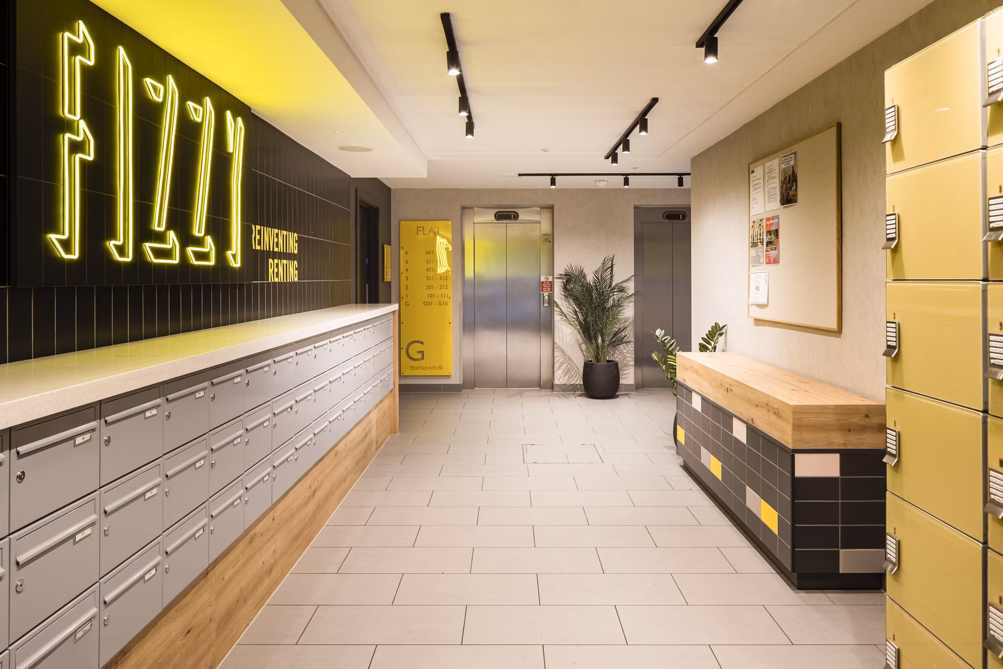 Lobby area at Fizzy Stepney Green with a 'Fizzy' neon sign, parcel lockers, and warm lighting.