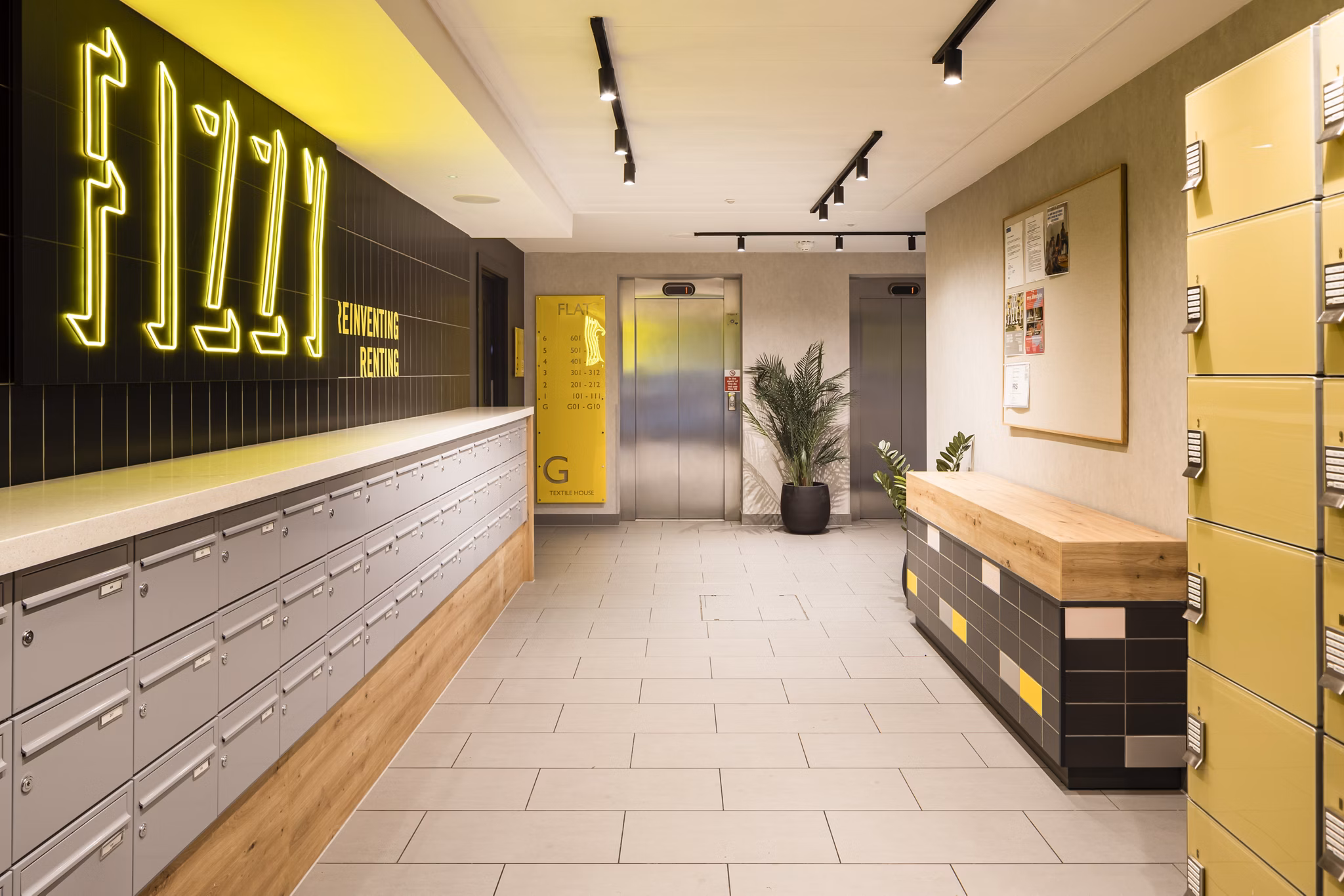 Lobby area at Fizzy Stepney Green with a 'Fizzy' neon sign, parcel lockers, and warm lighting.