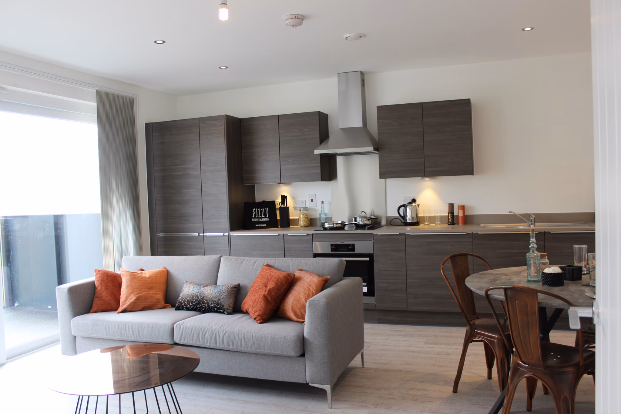 Open-plan kitchen and living space in Fizzy Walthamstow apartments with contemporary furnishings and warm accents.