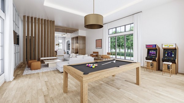 Spacious game room with pool table and arcade machines in luxury apartments featuring ample seating and large windows