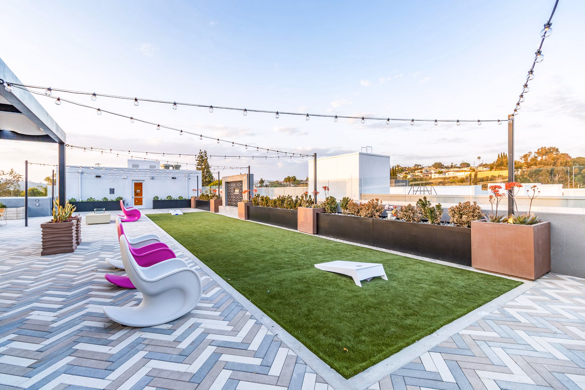 Outdoor recreational area with modern seating and greenery at Gravity Apartments
