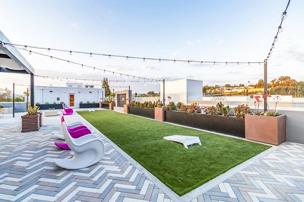 Outdoor recreational area with modern seating and greenery at Gravity Apartments