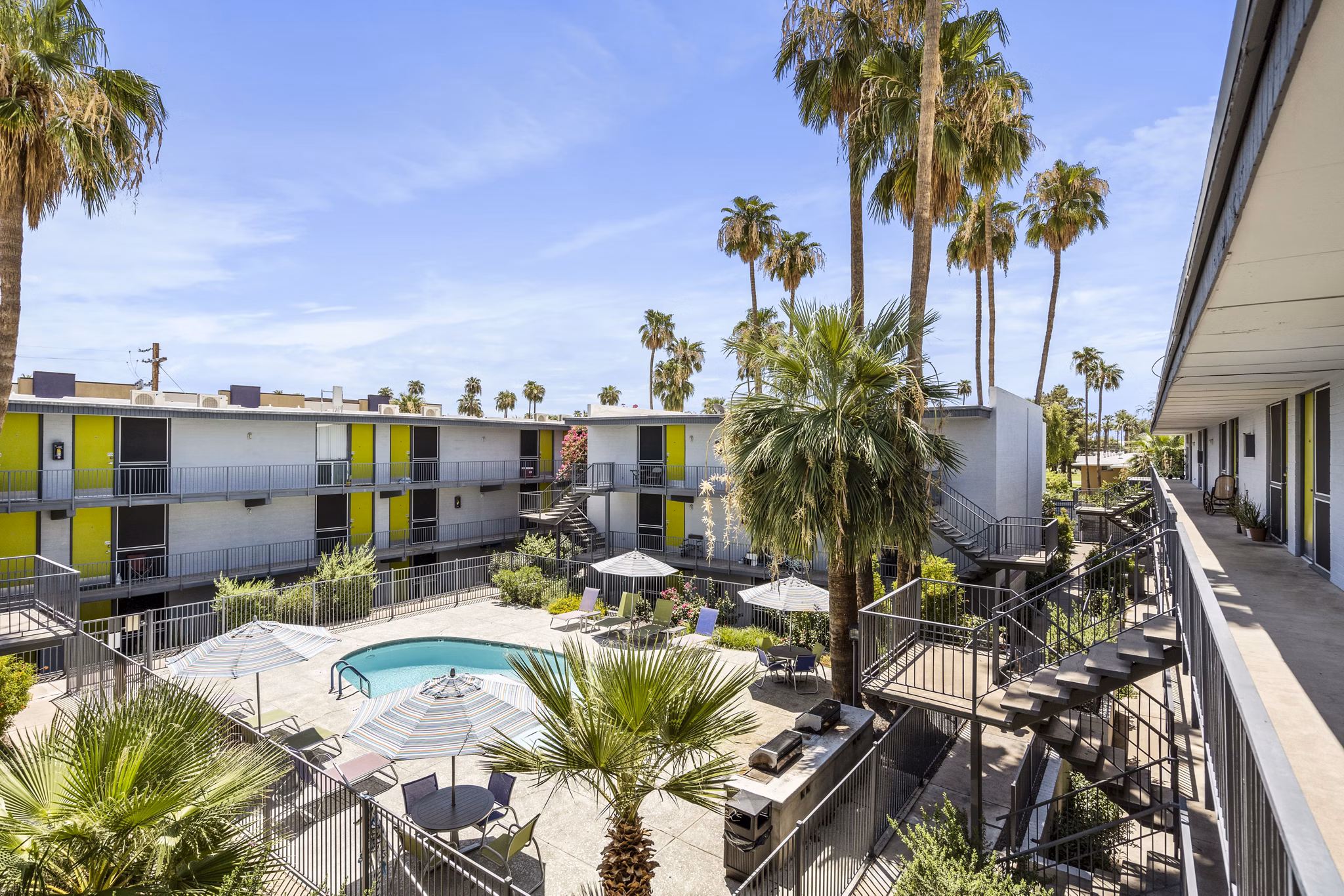 Resort-style pool with loungers at Crosstown Phoenix West Apartments, offering luxury amenities and leisure spaces