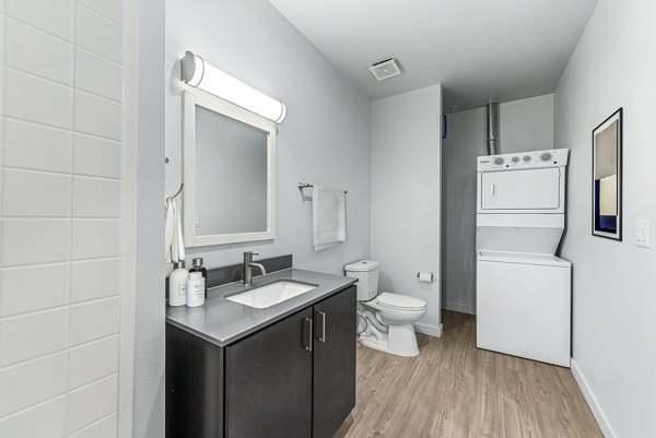 Contemporary bath and laundry room featuring sleek fixtures at FLATZ 432 Apartments