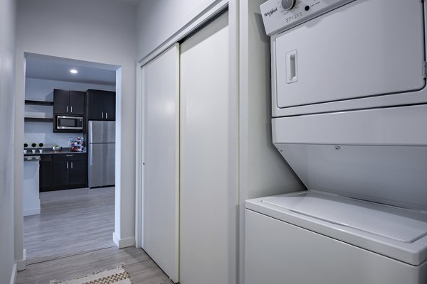 Laundry room with modern appliances at FLATZ 432 Apartments, convenient and efficient for urban living