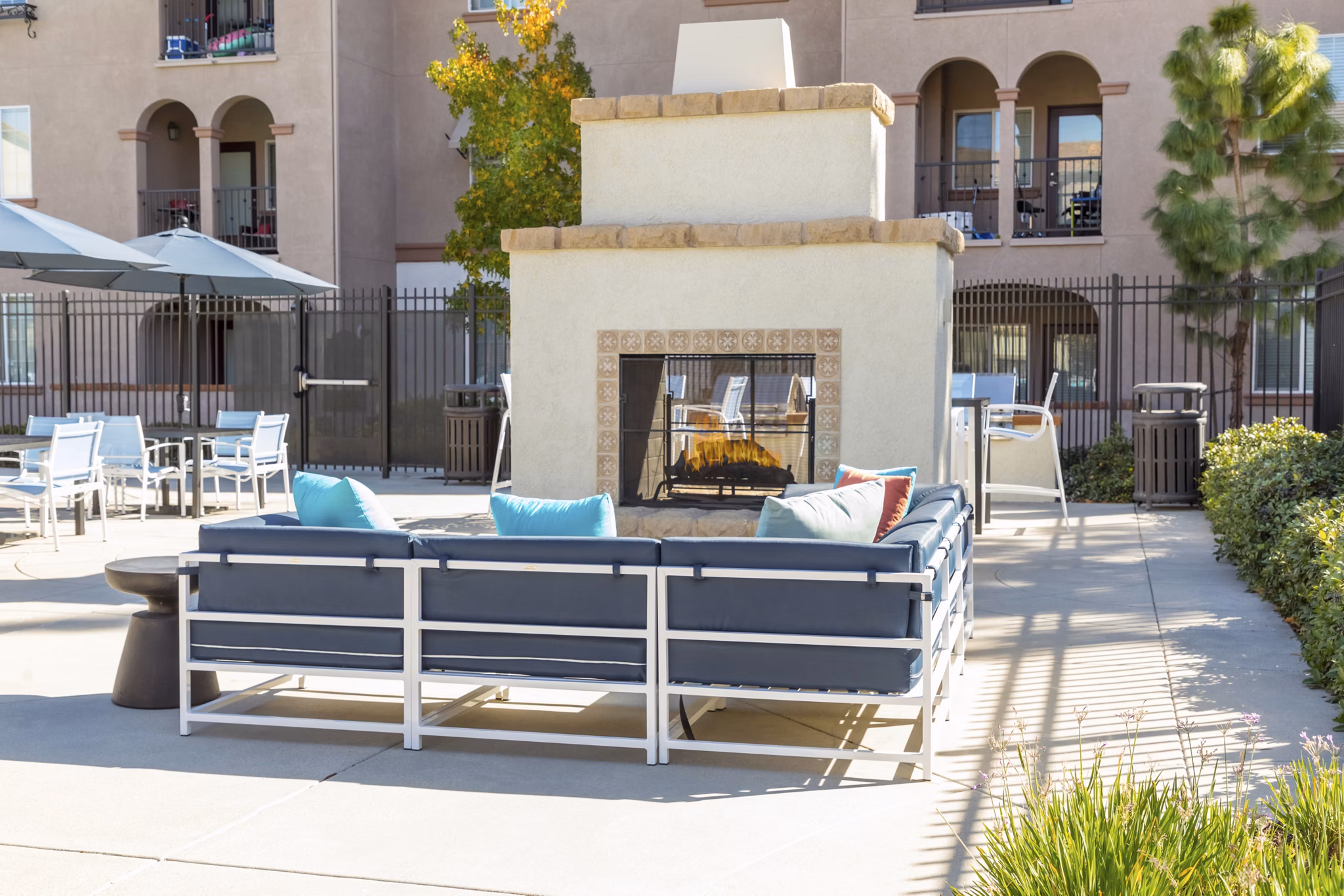 Fire pit area with comfortable seating at Viano at Riverwalk Apartments, perfect for social gatherings and relaxation