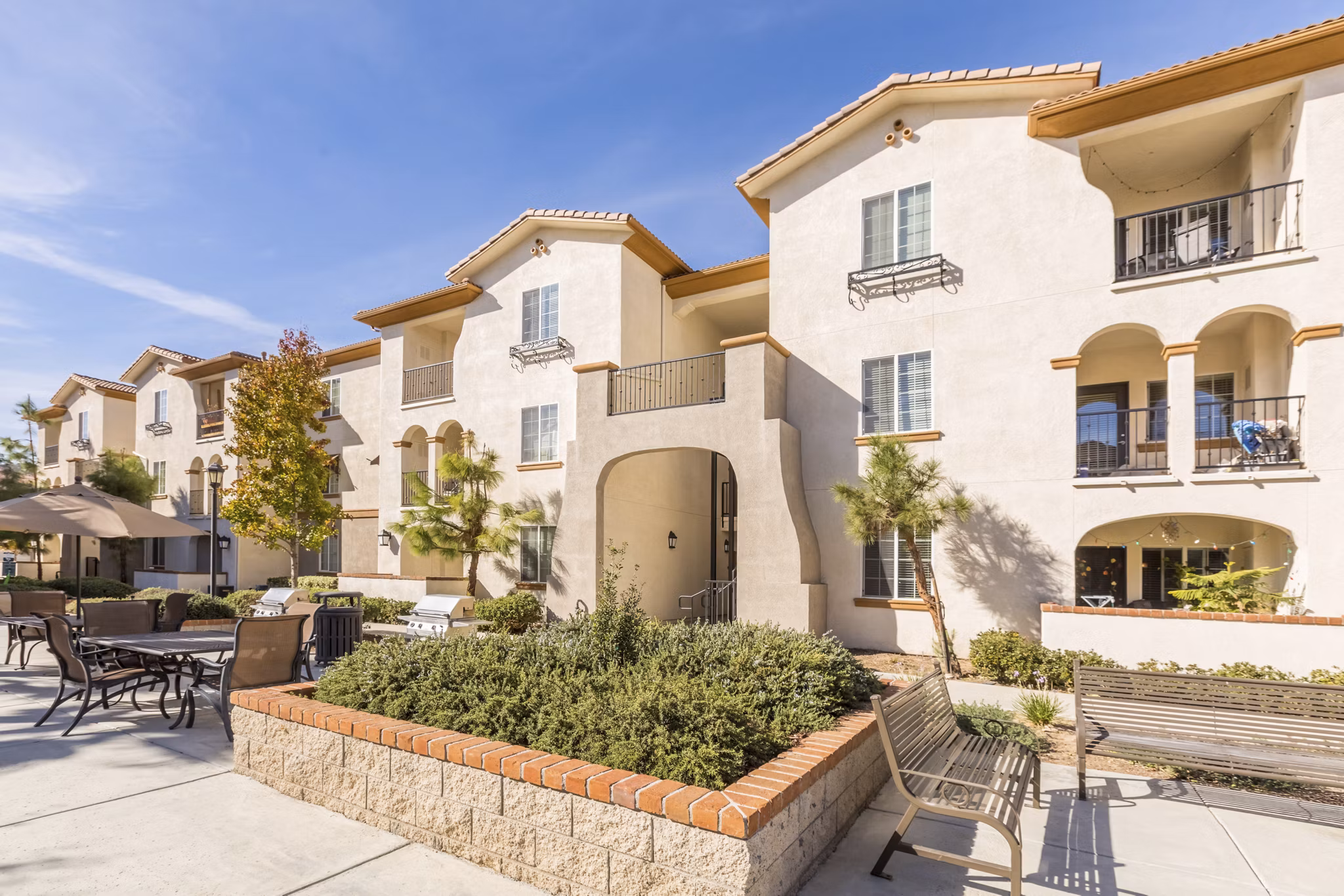 Viano at Riverwalk Apartments: Lush courtyard with seating and garden pathways for relaxation and social gatherings