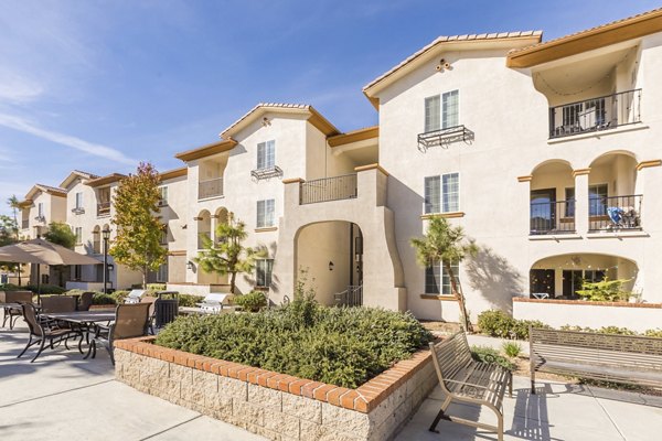 Viano at Riverwalk Apartments: Lush courtyard with seating and garden pathways for relaxation and social gatherings