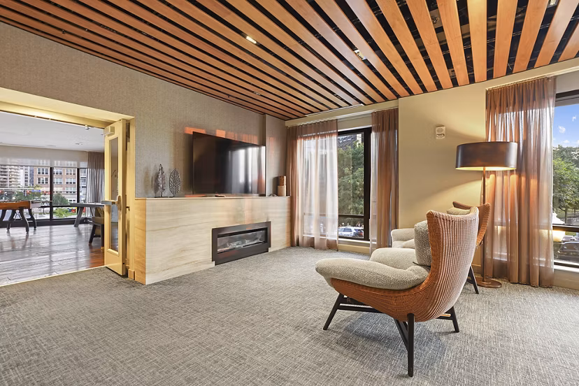 Clubhouse featuring modern design and ample seating at Vela on The Park Apartments